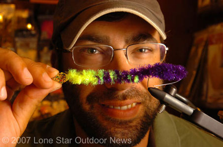 Underwater illusion: Fly-fishermen are using flies designed to imitate conventional bass tackle like spinnerbaits, crankbaits, jigs and worms. Sean Polk of Orvis in Dallas displays the Gulley Worm that he fishes like a Carolina rig when going after big bass. Photo by David J. Sams.