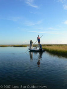 Capt. Chuck Scates poles Steve Faris to a pod of red tails in Fence Lake near Rockport Texas. Photo by David J. Sams