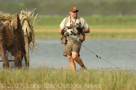 David Carroum, sporting shorts, winds up his Greenhead Gear decoys after the hunt. Photo by David J. Sams